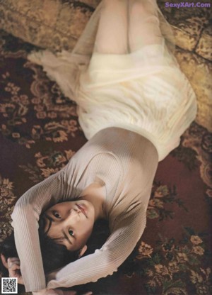 A woman laying on a couch in a room.