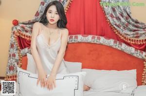 a woman sitting on top of a bed in a white lingerie