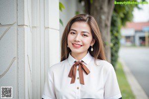 A woman sitting on a window sill wearing a white shirt and green skirt.