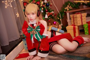 A woman dressed as a santa claus sitting on a window sill.