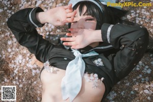 A woman in a school uniform is sitting on the ground.