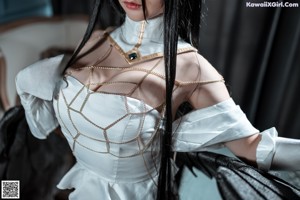 A woman in a white dress with black wings.