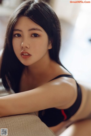 A woman in a black bra and panties holding a whip.