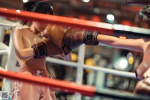 A woman in a boxing ring with boxing gloves on.