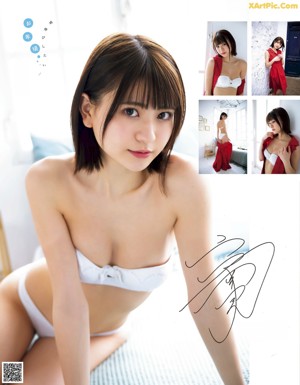 A woman in a blue bikini sitting on a white towel.