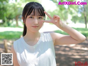 A young woman holding a white flower in her hand.