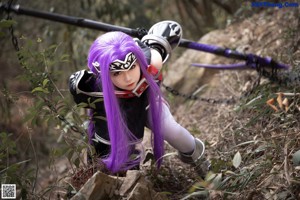 A woman with purple hair holding a bouquet of flowers.