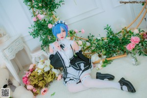 A woman with blue hair sitting on the floor next to a teddy bear.