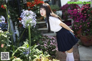 A woman in a school uniform posing for the camera.