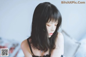 a woman laying on top of a bed next to pillows