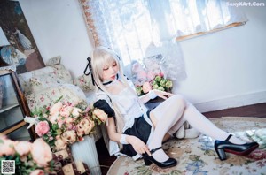 A woman sitting on a chair in a room with flowers.
