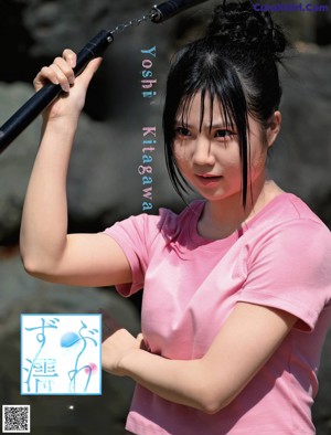 A woman in a pink shirt is holding a barbell.