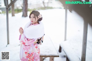 A woman wearing a white sweater and a white hat in the snow.