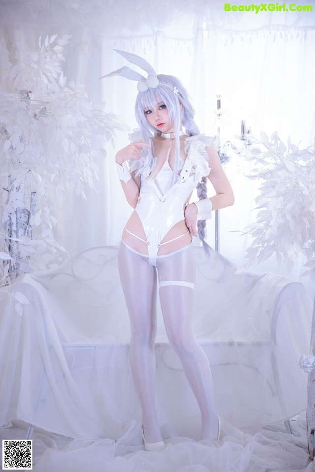 A woman in a white bunny costume posing for a picture.