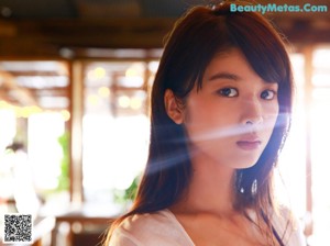 A woman in a white shirt and blue shorts posing for a picture.
