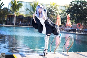 A woman with blue hair wearing a black and white jacket.