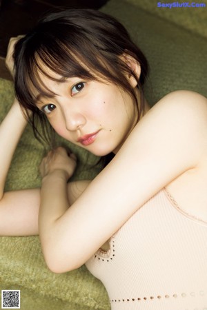 A woman laying on a bed in a white bra and panties.
