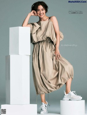 A woman in a white dress posing for a magazine.